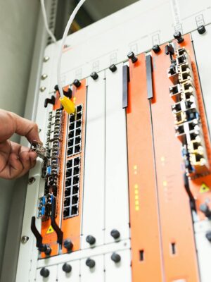 Close-up of a hand adjusting network equipment in a data center.